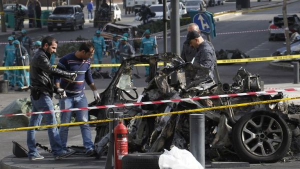 Lebanese police forensic experts inspect the wreckage of a car at the site of a powerful car bomb explosion on December 28, 2013 that rocked central Beirut the previous day. [AFP]