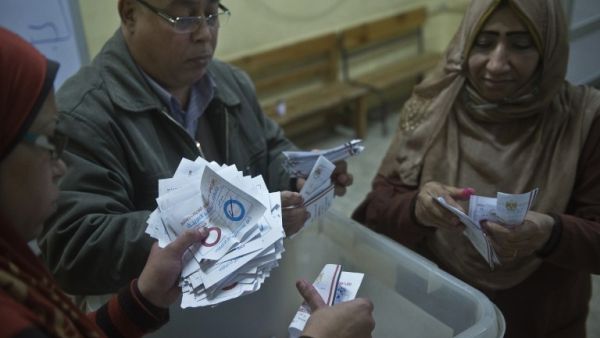 Polling station officials count ballots in the Egyptian capital Cairo on January 15, 2014 at the end of the second day of voting in a referendum on a new constitution. [AFP]