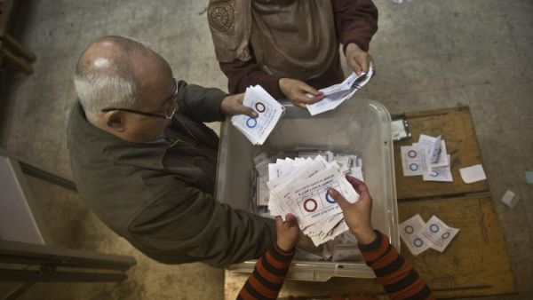 Polling station officials count ballots in the Egyptian capital Cairo on January 15, 2014 at the end of the second day of voting in a referendum on a new constitution. [AFP]