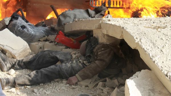 A body seen trapped under rubble after the most recent attack on Aleppo.  More than 130,000 people have been killed in Syria's nearly three-year war. [AFP]