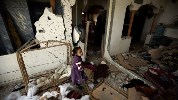 A Palestinian girl is seen inside the destoryed home of three-year-old Hala Abu Sabakha, who was killed during an Israeli air raid the day before, in the central of Gaza Strip, on December 25, 2013. [AFP]