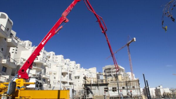 Laborers work on a new housing project at the Israeli settlement of Har Homa on the outskirts of mostly Arab east Jerusalem, near the West Bank biblical town of Bethlehem, on December 02, 2010. [AFP]