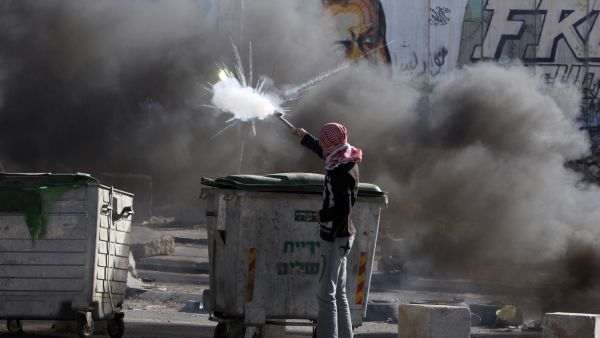A Palestinian youth clashes with Israeli border guards in the West Bank's Qalandiya refugee camp on August 26, 2013, after Israeli security forces shot dead three Palestinians and wounded 19 others in the camp. (AFP)