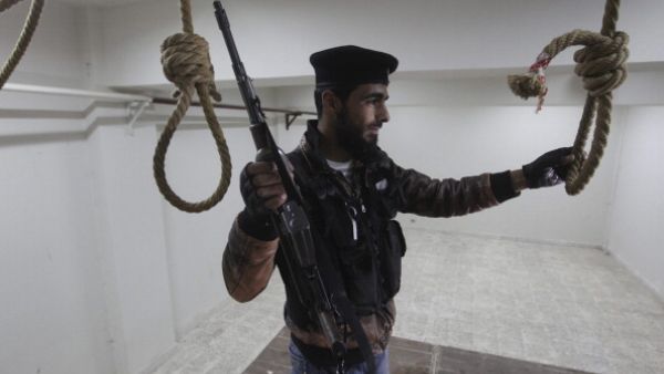 A Free Syrian Army soldier in a room where political prisoners were hanged by Al-Assad forces inside the central prison on April 23, 2013, in Darkoush, Syria. [Getty Images]