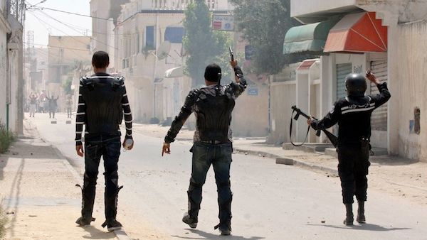 Security forces gesture towards Ansar Al Sharia protestors in the Ettadhamen, Tunisia on Sunday. AFP