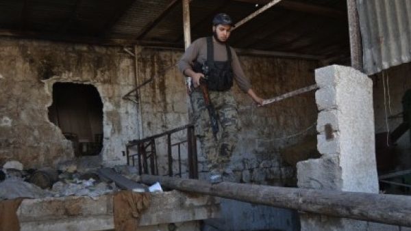 An opposition fighter walks along a log in the northern Syrian city of Aleppo on October 6, 2013. Syria's army took back control of a strategic town in the northern province of Aleppo on October 3, after a weeks-long battle for the city. (AFP) 
