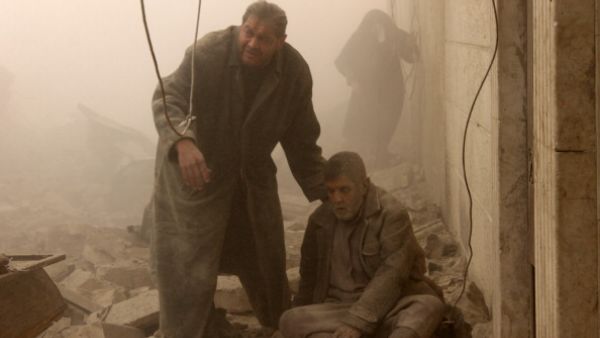 A Syrian man helps an injured man following an airstrike in Aleppo's Maadi neighborhood on December 17, 2013. [AFP]