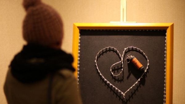 A woman visits the exhibition 'Chic-Art-Resistance' by Palestinian artist Sami Musa in the West Bank city of Ramallah, on December 10, 2013.  [AFP]
