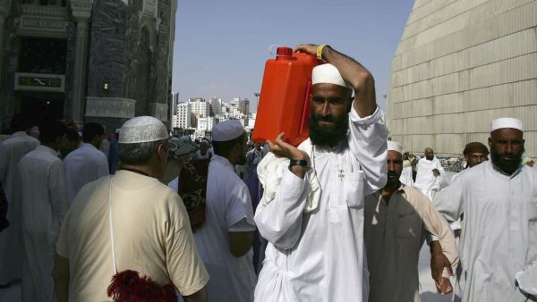 A Muslim pilgrim carries a gallon container of water from the Zamzam well the source of which comes from under the great mosque, Mecca.