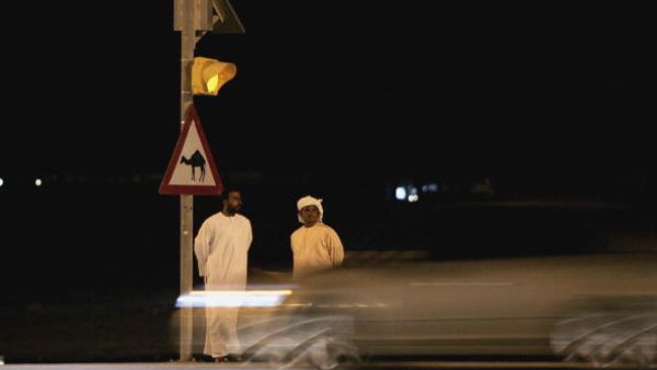Two men wait to cross the road in a country where red lights are routinely ignored (Getty)