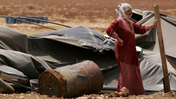A Palestinian bedouin woman stands next to her destroyed tent in the village of Atouf in the Jordan Valley (AFP/File)
