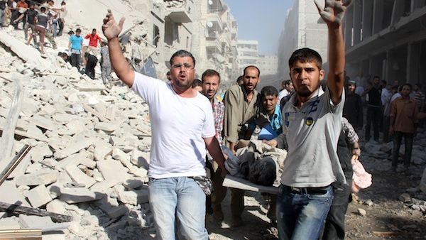 Syrians men evacuat a victim following an air strike by regime forces in the northern city of Aleppo on August 26, 2013. (AFP)