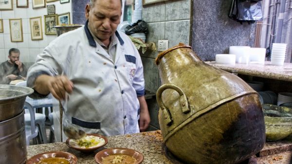 Just about everything at Hashem Restaurant exudes the grittiness of this city's rough-and-tumble downtown: chefs in white aprons
scoop fuul (fava beans) out of vase-shaped metal jars and plop it on to plastic bowls.