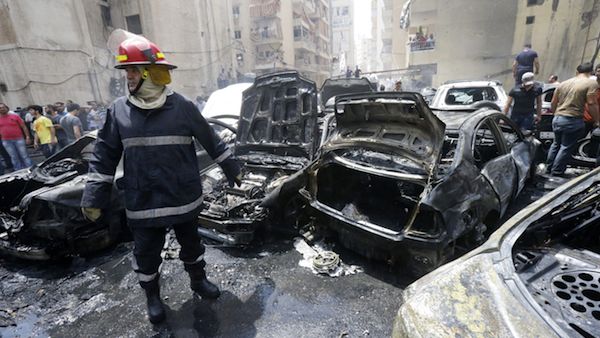 A firefighter stands after extinguishing fire from vehicles at the site of an explosion in Beirut's southern suburb neighbourhood of Bir al-Abed on July 9, 2013. (Source: AFP/STR)