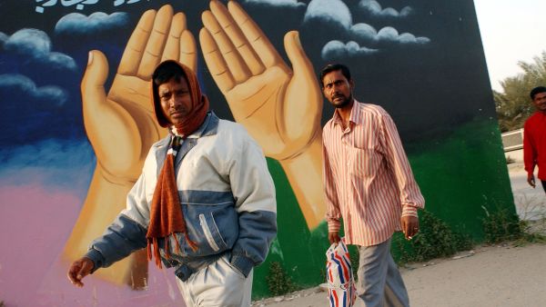 Immigrants standing by a mosque in Kuwait. 