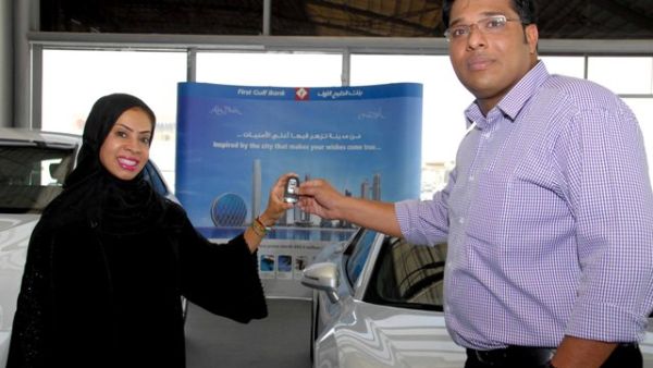 Huda Abdulla, Executive Vice President - Branch Distribution at First Gulf Bank presenting one of the half yearly draw winners with an Audi R8 Quattro