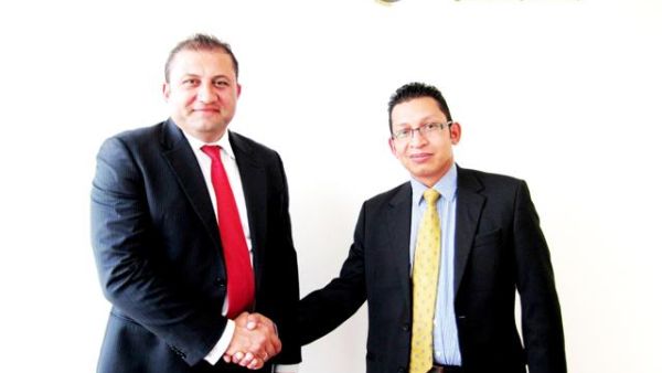 EMW CEO and Interactive Intelligence Territory Manager shake hands after the signing