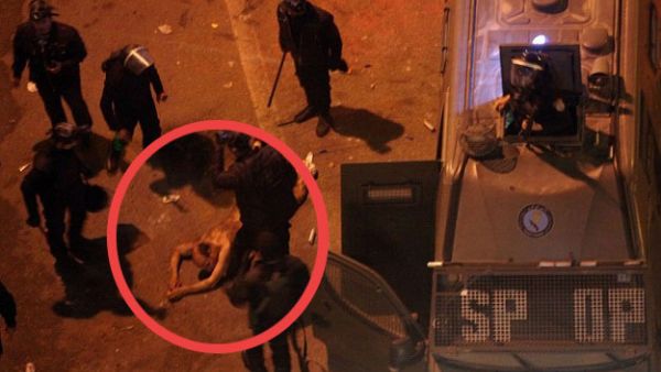 Stripped naked and beaten-- where are the police? They are the ones administering the blows.