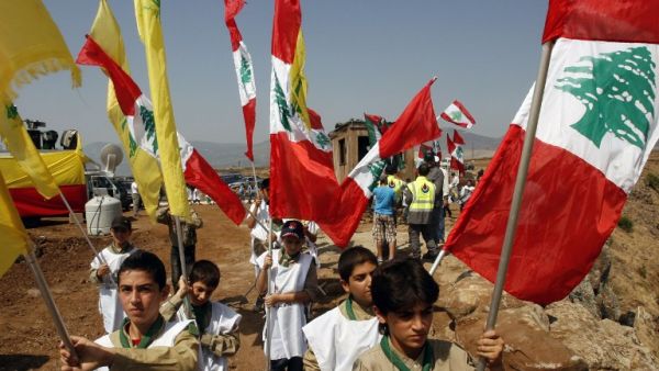 Young boys of Hezbollah's al-Mehdi scouts wave Lebanese and Hezbollah flags during a parade in the southern area of Wazzani river on the Lebanese-Israeli borders, on August 2, 2013. (AFP)