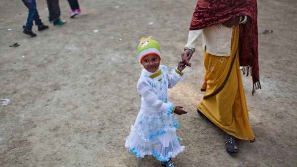 An Indian girl walks with her mother