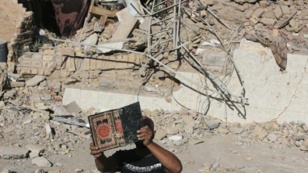 An Iraqi man retrieves a copy of the Koran from the debris of the Al-Hussein mosque following an explosion in the district of al-Musayyib, south of Baghdad on Monday. The Islamic State of Iraq and the Levant on Tuesday claimed responsibility for the attacks. (AFP)
