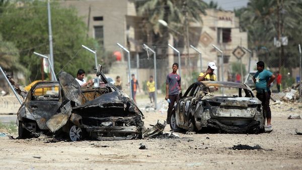 Iraqis inspect the scene of a car bomb attack near the office of Al-Ahad television channel, which is affiliated with a Shiite militant group, in Baghdad's eastern neighbourhood of Baladiyat on August 15, 2013. (AFP)