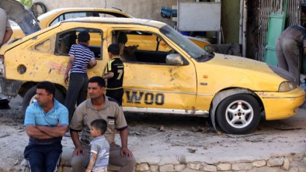 Iraqis look on at the site of a car bomb attack the evening, before in the Zafaraniyah area south of Baghdad, on October 8, 2013. A wave of car and roadside bombs hit Iraq on Sunday morning, killing at least 8 people. (AFP)
