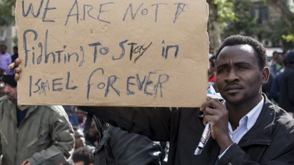 A protestor holds up a sign in English as thousands of African asylum seekers who entered Israel illegally via Egypt staged a protest in Tel Aviv on January 7, 2014, slamming the Jewish state's long-term detention of African migrants. The protest continued to Jerusalem on Wednesday. (AFP)