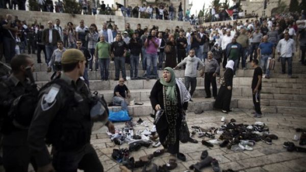 A Palestinian woman yells at Israeli security forces during a demonstration in front of Jerusalem's old city's Damascus gate on Tuesday. Israeli forces on Wednesday stormed the Al Aqsa mosque compound, the third holiest site in Islam. (AFP)

