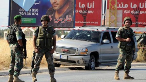Lebanese soldiers at the site of a car bomb attack on a Hezbollah convoy travelling towards the border crossing with Syria on Tuesday. [ AFP]