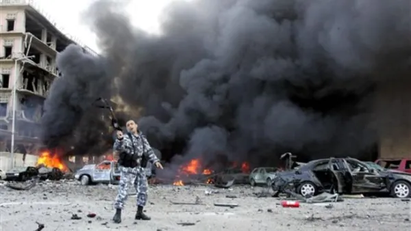 A picture taken on February 14, 2005 shows a Lebanese police officer gesturing on the site of an explosion which killed former Lebanese premier Rafiq Hariri and 21 others in Beirut. The Beirut government is in paralysis, business deals are on hold and tongues abuzz with rumours as Lebanon anxiously awaits indictments by a UN tribunal probing Hariri's murder.