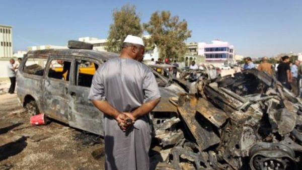 Benghazi residents gather at the site of a car blast in the parking lot of school used as an electoral office on October 26, 2013. On Sunday night, a Libyan intelligence officer and his two-year old son were killed in a car bomb attack. (AFP)
