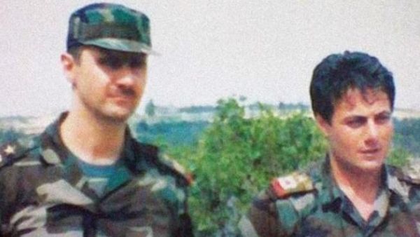 An undated photo showing a young Manaf Tlas (right) next to President Assad
