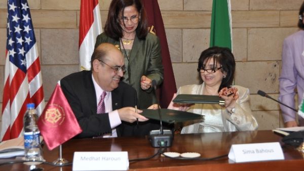 Medhat Haroun and Sima Bohous signing the MoU and behind them standing is Malak Zaalouk