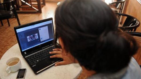 A woman looks at a Facebook page in Agadir published in support of the three Moroccan teenagers arrested for posting Facebook photos of two of them kissing outside their school in the northern town of Nador last week. (AFP)