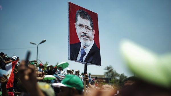 Egyptian Islamist groups led by the ruling Muslim Brotherhood shout slogans during a demonstration to mark the upcoming one year anniversary since President Mohamed Morsi (portrait) was elected, on June 21, 2013 in Cairo. (AFP)