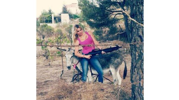 Myriam posing with her two favorite things: Guns and donkey "Fairuz." (Image: Fairuz)