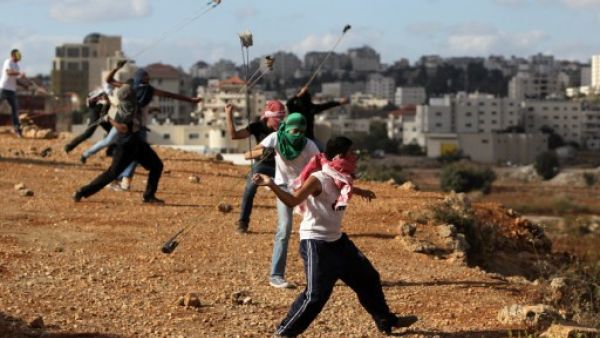 Palestinian protesters hurl rocks at Israeli soldiers during clashes in Betunia near the West Bank city of Ramallah on October 4, 2013. The Palestinian and Israeli delegations locked horns at the IPU meeting in Geneva on Wednesday. (AFP)
