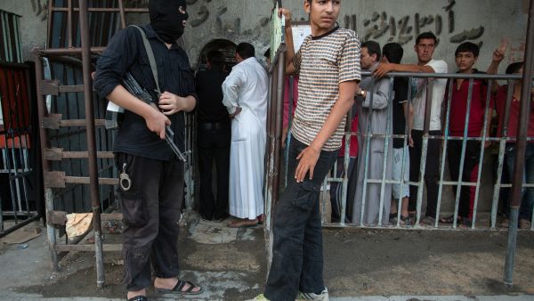 An armed man wearing a balaclava (ski mask) stands guard outside a bakery run by the Islamic rebel group "Ahrar Al-Sham", in the northern city of Raqqa (AFP/ALICE MARTINS)