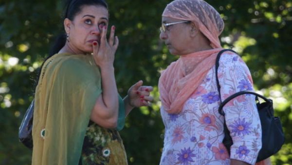 A woman wipes away a tear in front of the Sikh Temple of Wisconsin where at least one gunman stormed the mass and opened fire August, 5, 2012 Oak Creek, Wisconsin.