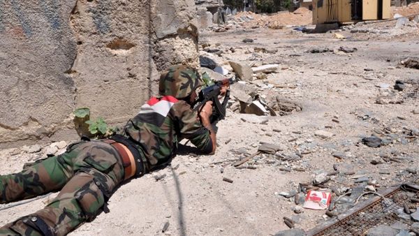 A member of the Syrian armed forces takes position during a patrol near Al Manashir roundabout in Jobar in the outskirts of Damascus on July 14, 2013. (AFP/SANA)