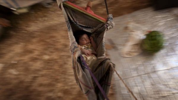 A Syrian refugee baby sleeps in a hammock at the Bab al-Salam refugee camp in Syria's northern city of Azaz on 15 July 2013. (AFP/File)