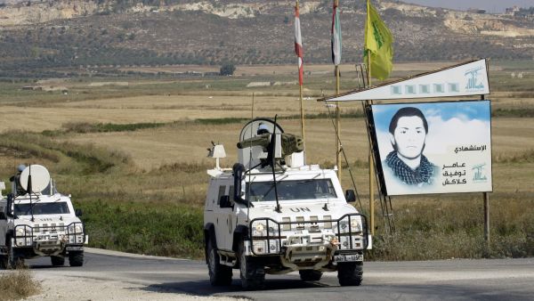 Spanish peacekeepers of the United Nations Interim Force in Lebanon (UNIFIL) patrol in their armoured vehicles near a placard of Hezbollah (AFP/MAHMOUD ZAYYAT)