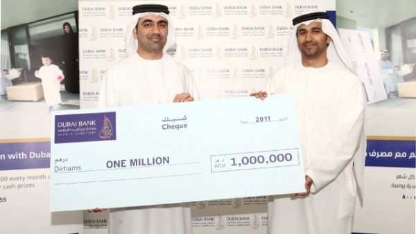 Waleed Al Awadi handing the Kunooz winner's cheque to winner Eisa Al Hammadi