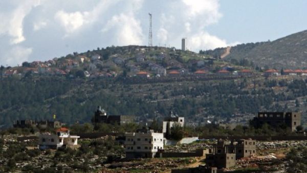 The general view of the Jewish settlement of Itamar (background) behind the West Bank village of Awarta. Israeli settlers are seeking approval for hundreds of homes in the northern West Bank. AFP photo