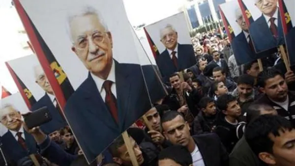 فلسطينيون يحملون صورا للرئيس الفلسطيني محمود عباس في رام الله
