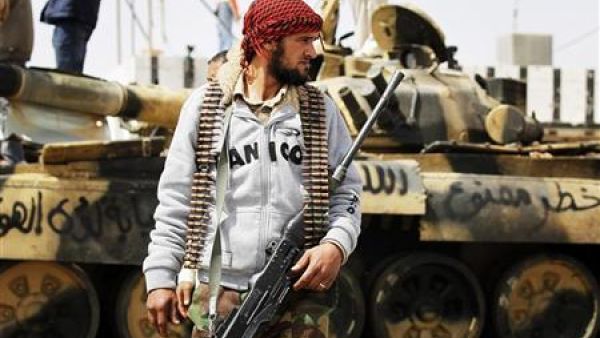معارض مسلح أمام دبابة تخلت عنها قوات القذافي قرب اجدابيا
