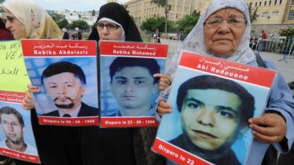 نساء يحملن صور اقاربهن المفقودين في الجزائر