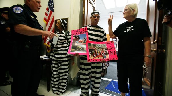 Free us 'from' the flotilla say American woman, still stranded,  who planned to free Palestine's Gaza blockade by their
 water-borne endeavor. Prisoners by American authorities in Greece. Still.