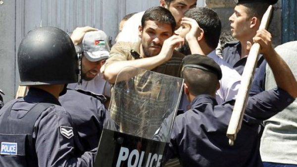 عناصر من الشرطة الاردنية يعتقلون متظاهرا في عمان
